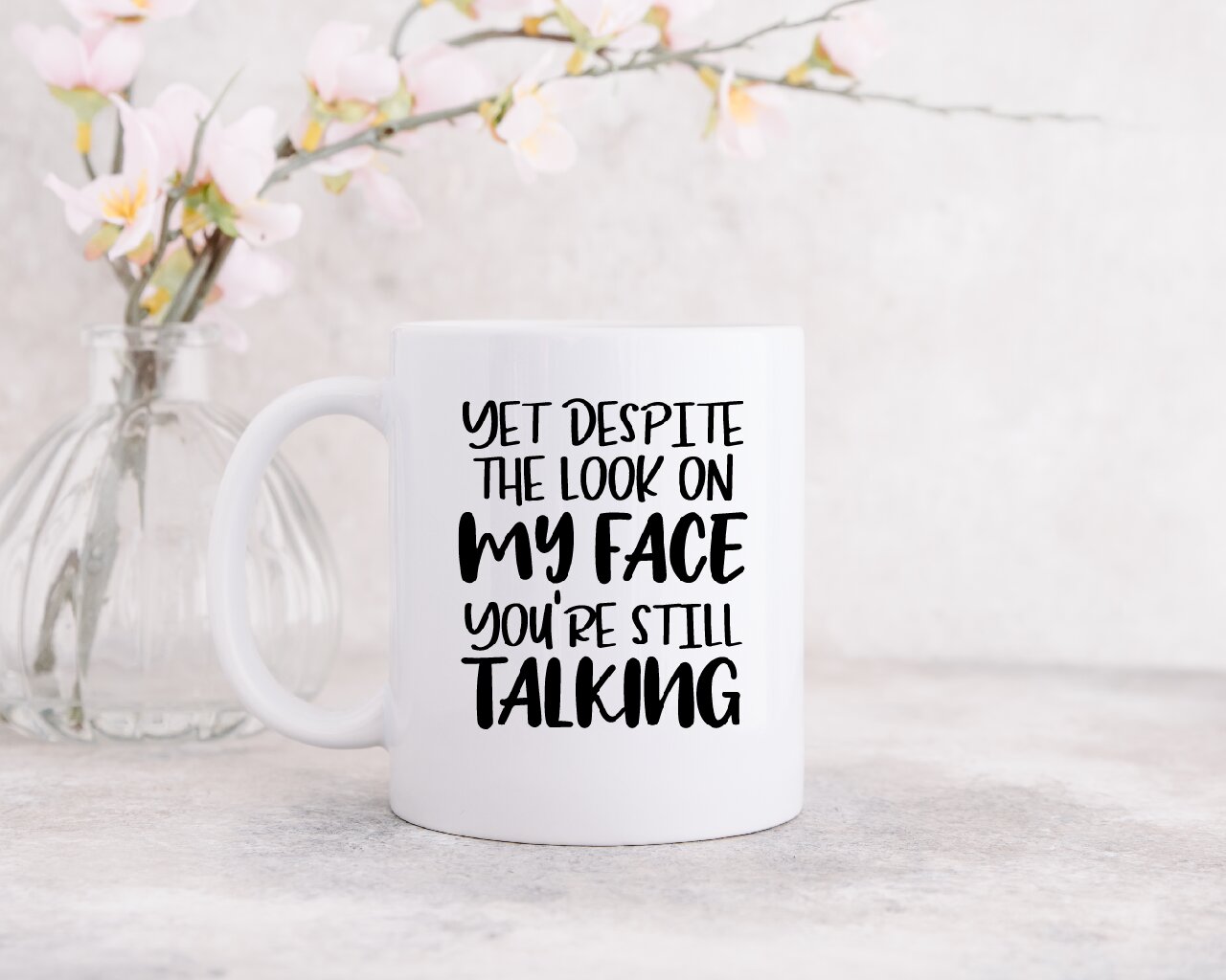 Yet Despite The Look On My Face, You're Still Talking - Coffee Mug